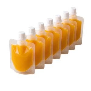 Seven Gingerly Yours ginger and turmeric wellness shot pouches arranged in a row on a white background.
